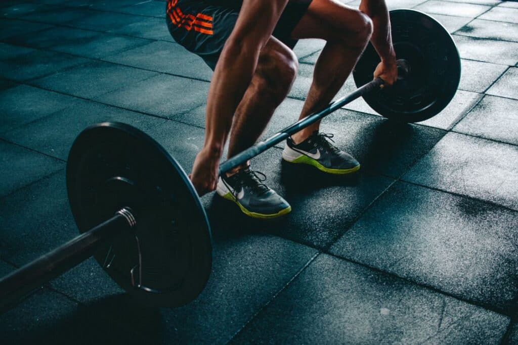 Person holding a barbell in a gym - UK gym membership hits record 12.2 million