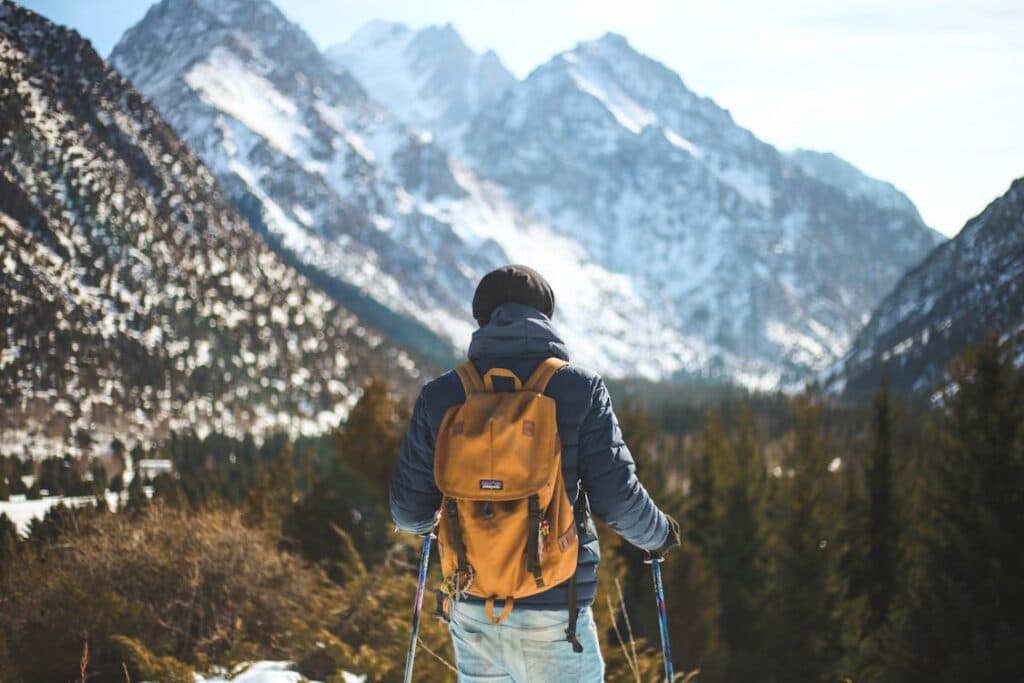Person walking outdoors with a weighted backpack - rucking fitness trend