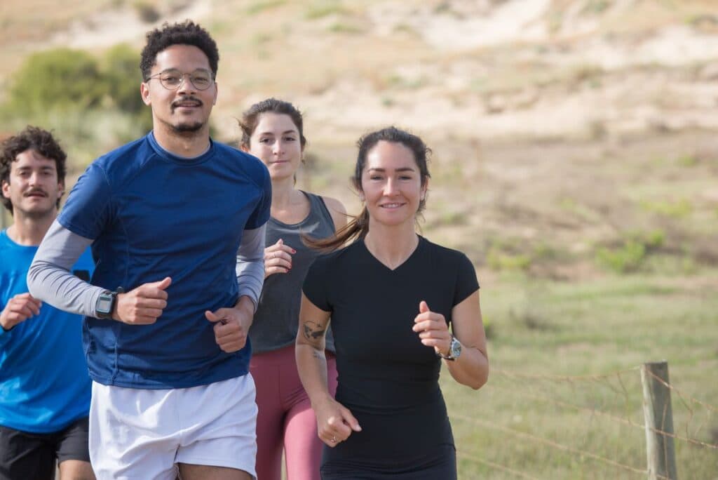 A group of people running together outdoors in a park, representing the parkrun community